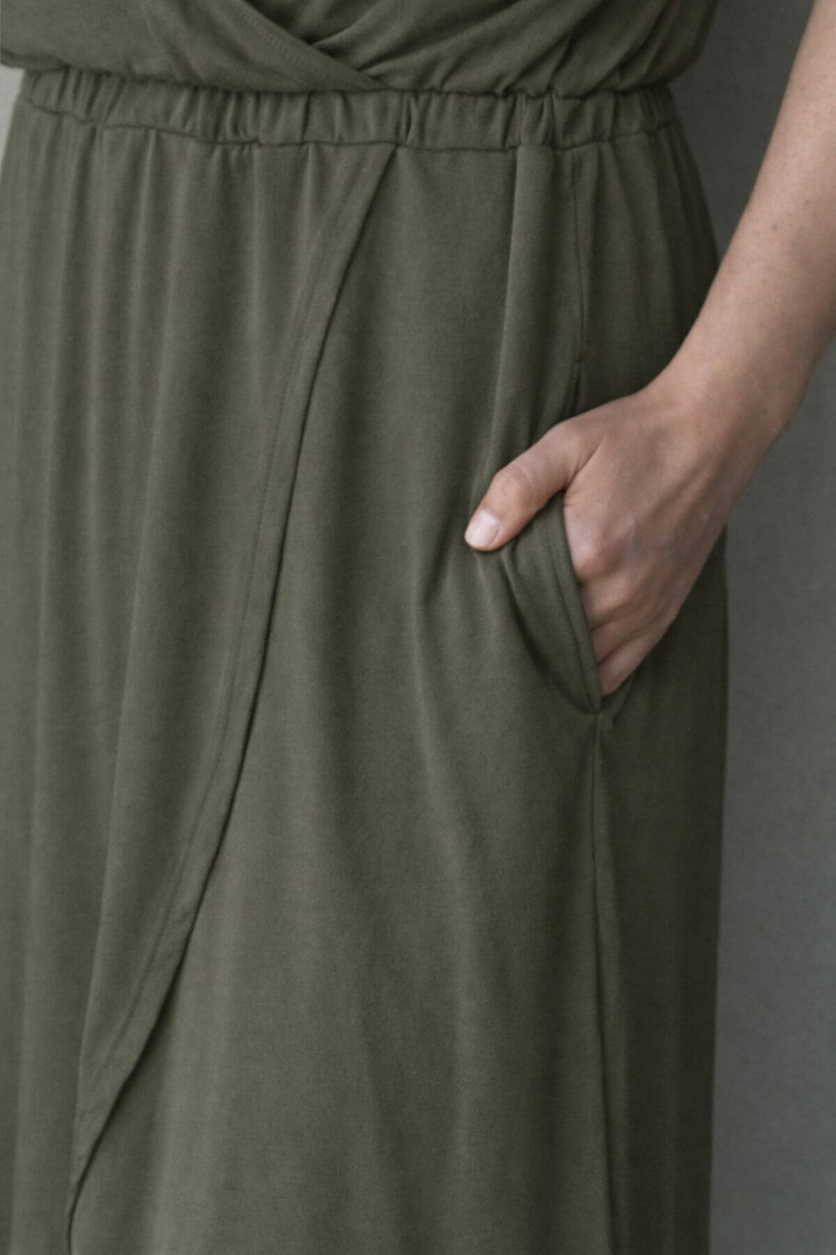 Olive green nursing dress with a pocket on a plain background