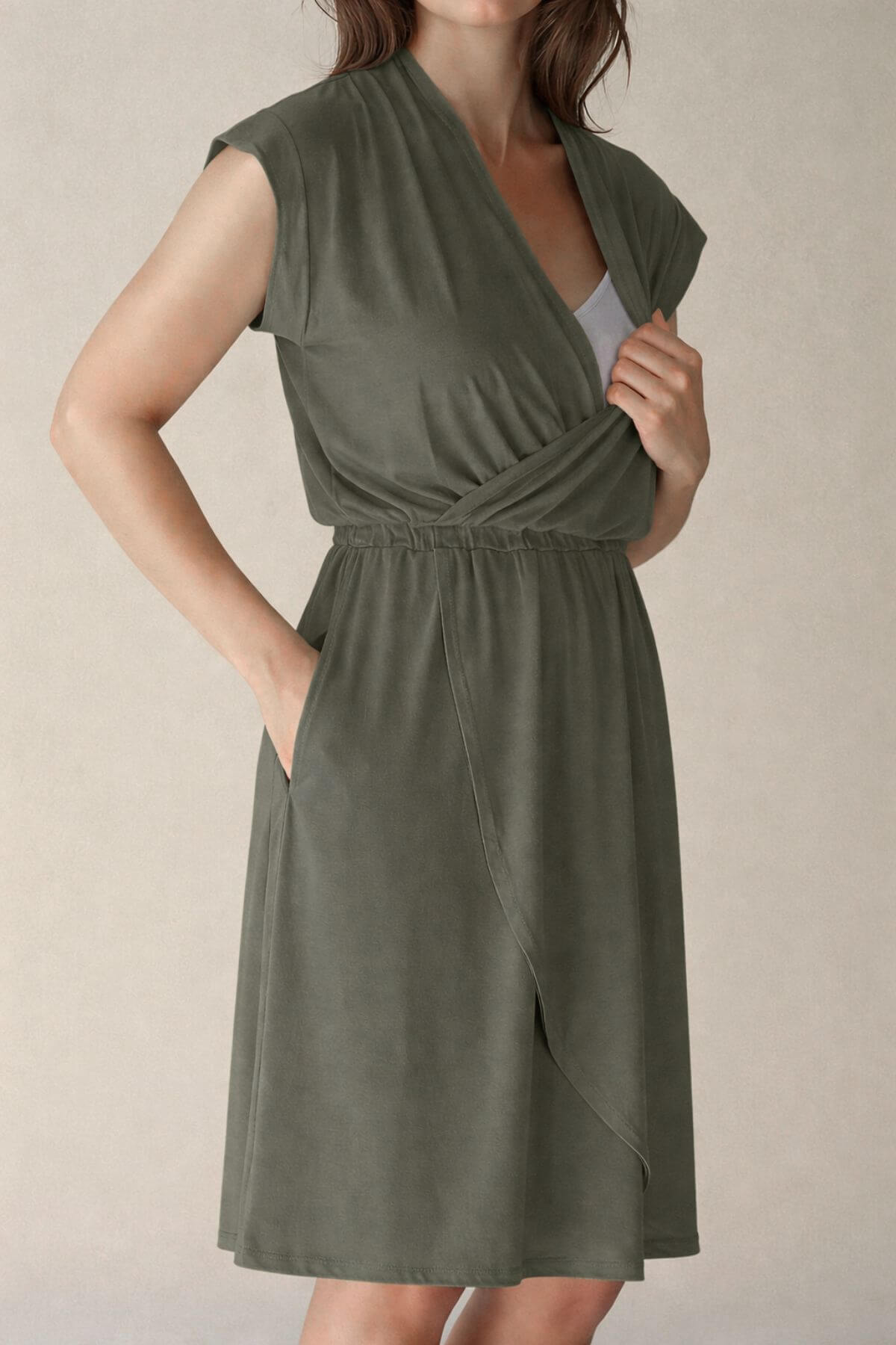 Woman wearing a green nursing dress against a beige background