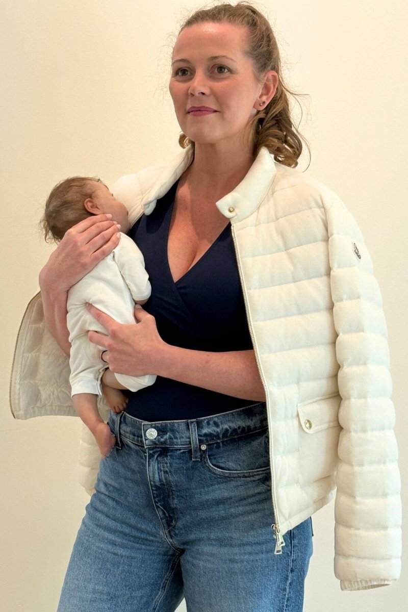 Simple Nursing Tank Midnight seated lifestyle mom holding baby styled with a white puffer jacket