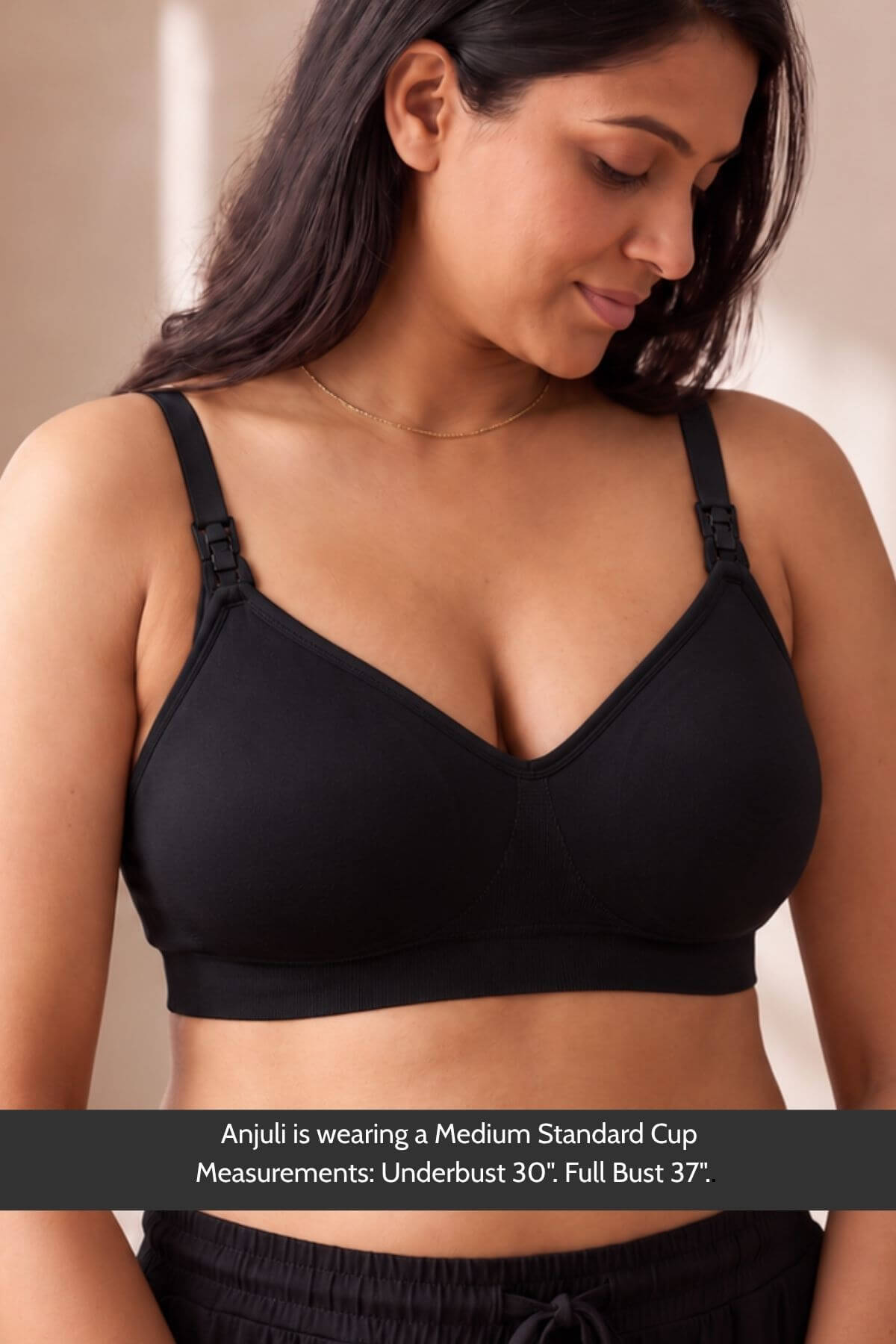 A woman wearing a simple wishes silhouette nursing & hands free pumping bra with front adjustable shoulder straps, shown from the chest up against a soft beige background. A text banner at the bottom reads: &