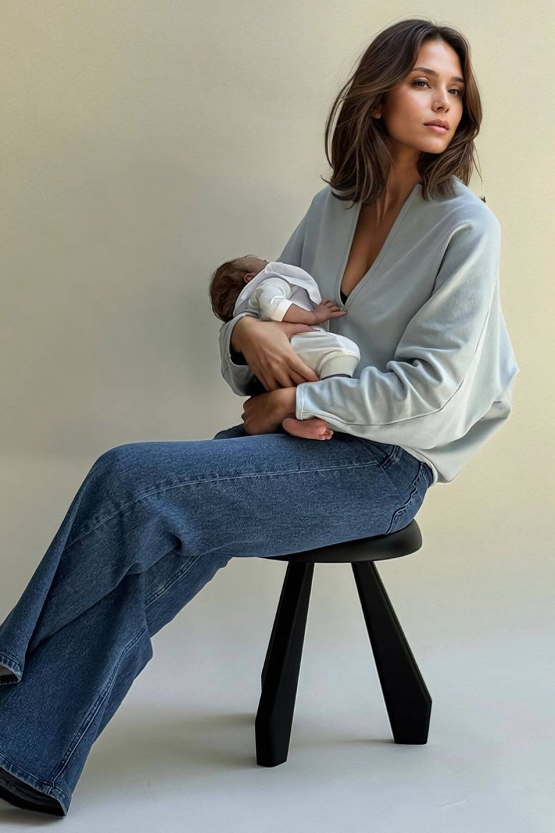 Aspen Breastfeeding Fleece Pullover front view deep v-neck mom holding baby seated on black stool