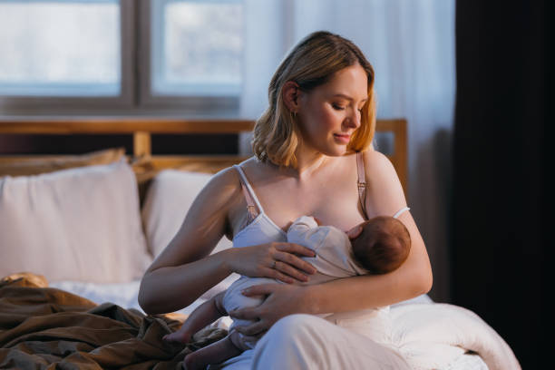 Parent Nursing A Baby In A Calm Bedroom, Illustrating “How Long Should You Breastfeed" At Different Stages