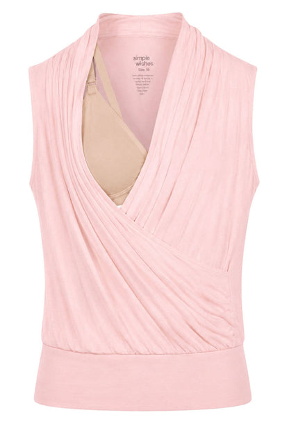 A light pink sleeveless wrap-style top with a draped cowl neckline, shown on a white background with a beige bra underneath for support. The inner label reads &