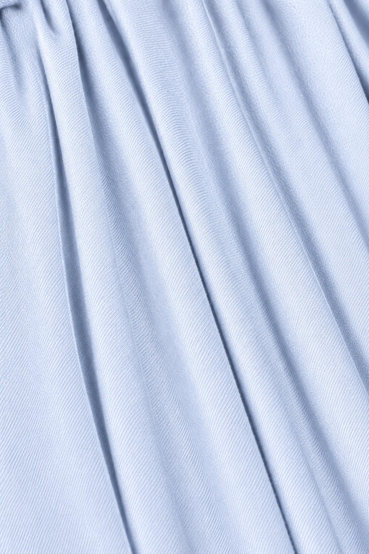 A close-up of light blue pleated fabric with soft vertical folds and a fine ribbed texture.