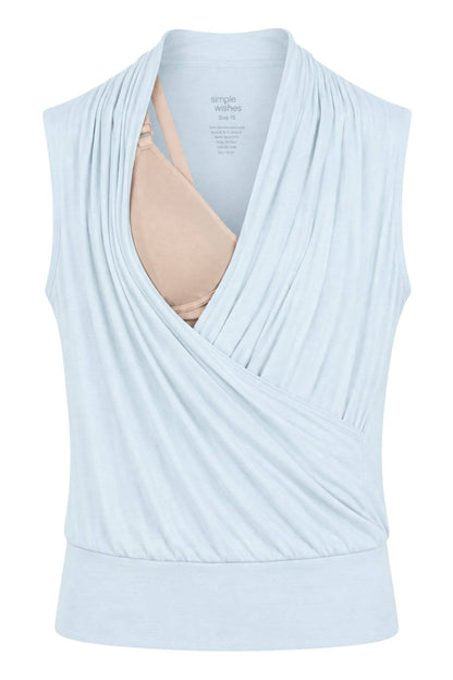 A light blue maternity nursing tank top with a draped crossover front, shown on a white background with a beige nursing bra underneath for demonstration..