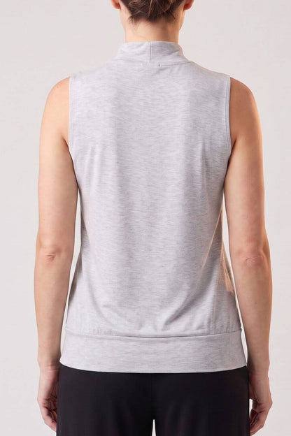 A woman viewed from the back wearing a light gray sleeveless mock-neck athletic top and black pants, against a plain light gray studio background.