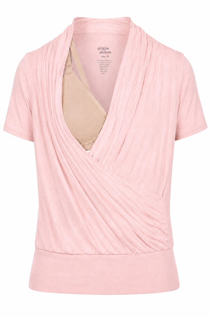 A light pink short-sleeve wrap-style top with a draped front and a beige underwire bra visible inside, shown on a white background.