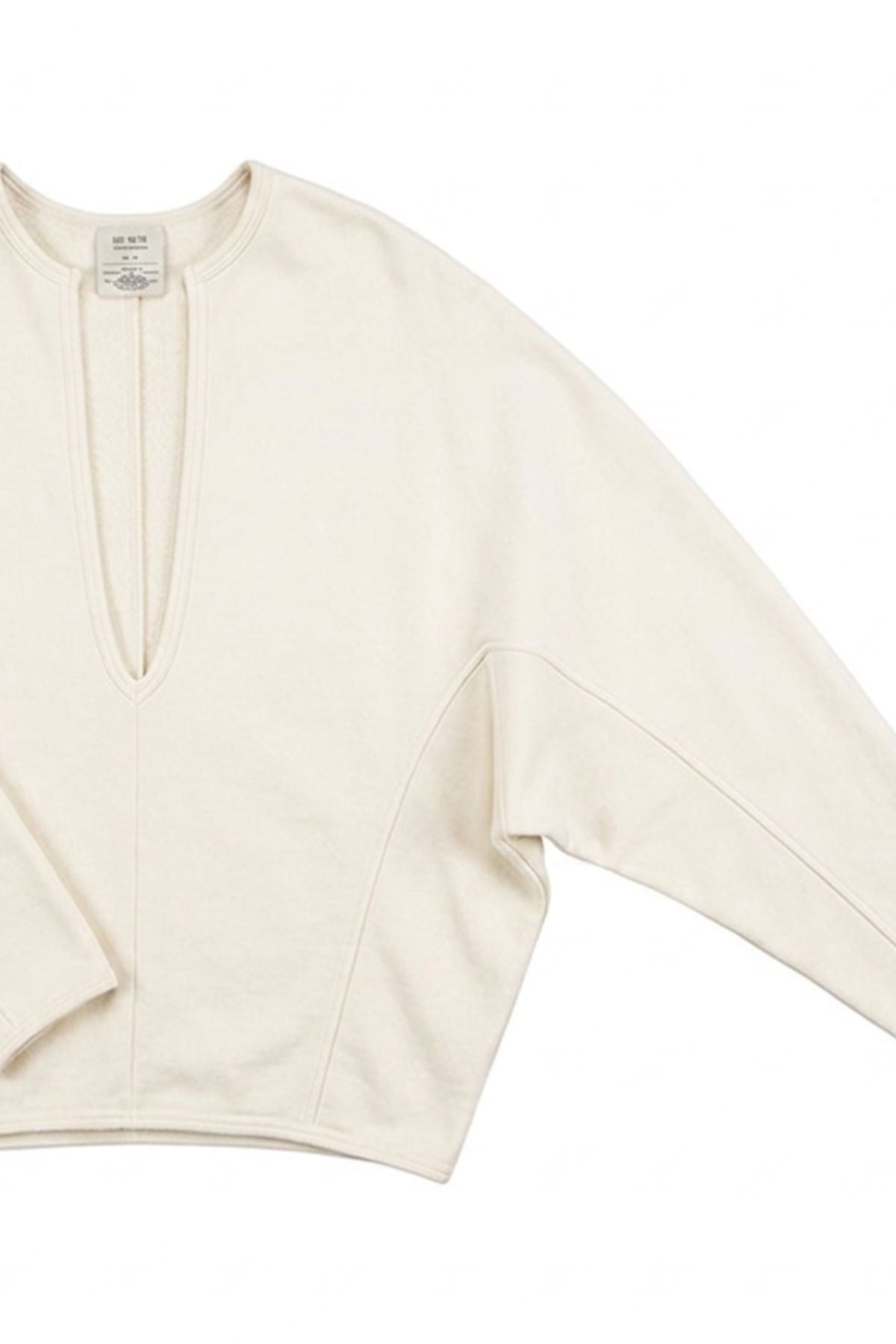 An off-white long-sleeve knit top with a split V-neckline, laid flat against a white background.