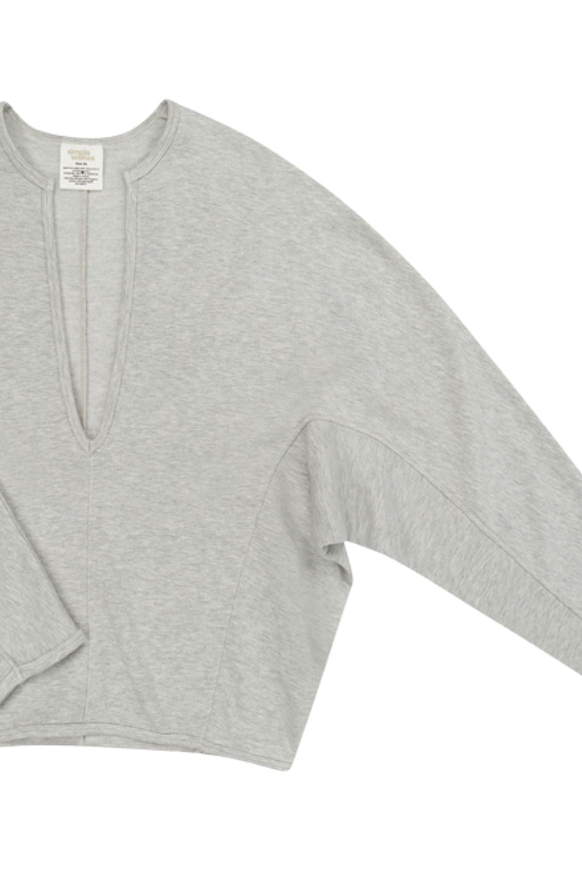 A light gray heather knit top with a split V-neckline and long sleeves, shown on a plain white background.