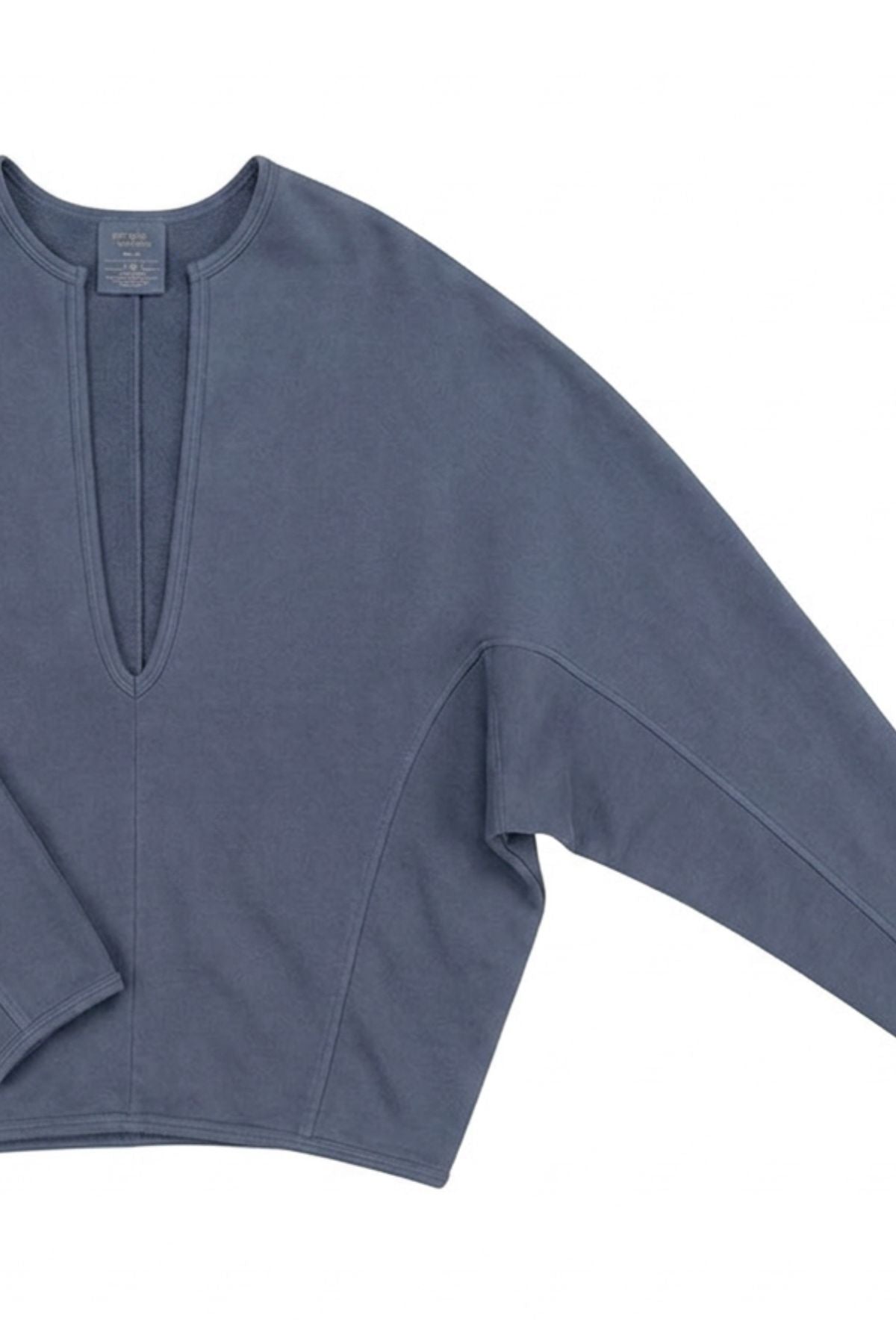 A slate blue cropped long-sleeve top with a split V-neckline, laid flat against a white background.