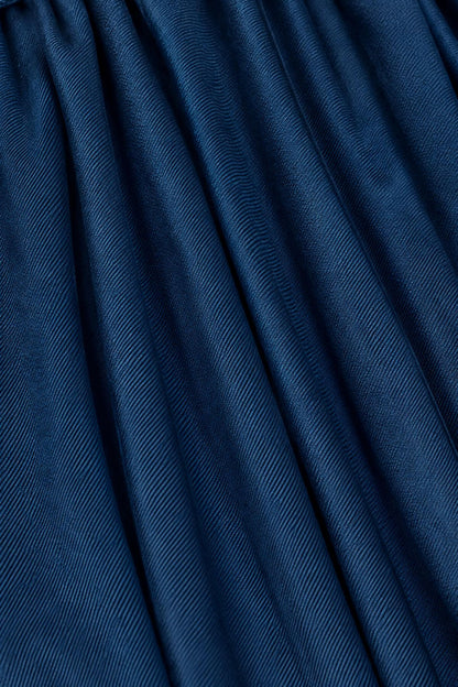 A close-up of dark blue textured fabric with a fine diagonal ribbed pattern and soft folds.