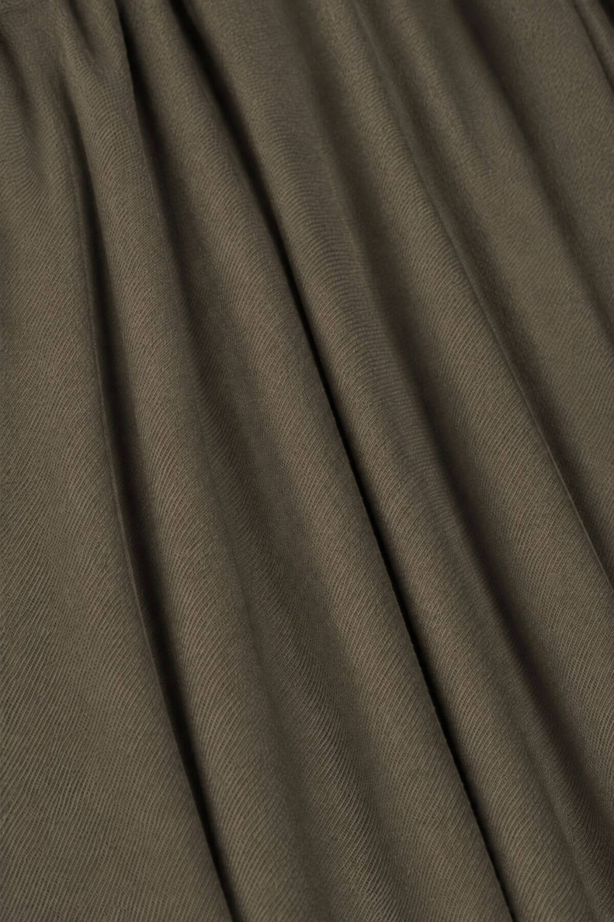 A close-up of draped olive brown fabric with soft folds and a fine textured 