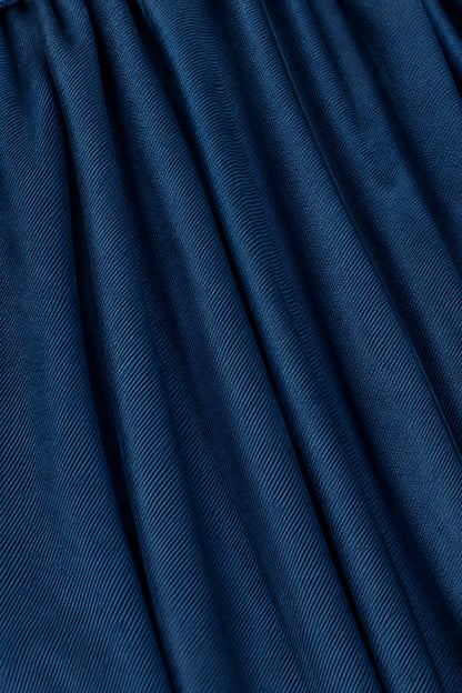 A close-up of dark blue textured fabric with a fine diagonal ribbed pattern and soft folds.