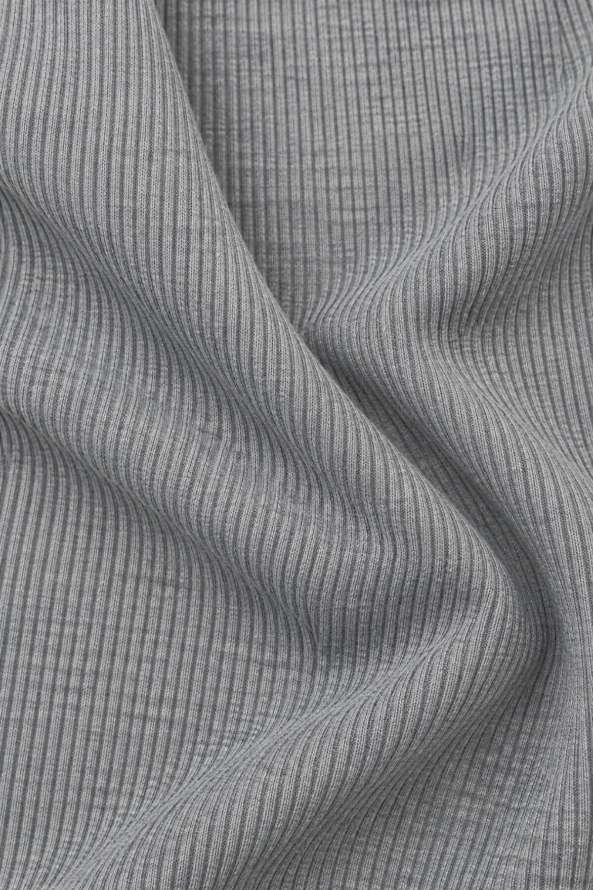 Close-up of a gray ribbed knit fabric with a fine vertical stripe texture, draped in soft folds.