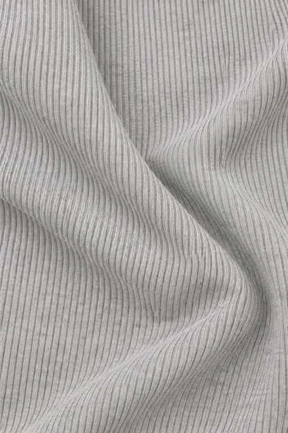 Close-up of a light gray ribbed knit fabric with vertical fine stripes and soft folds.