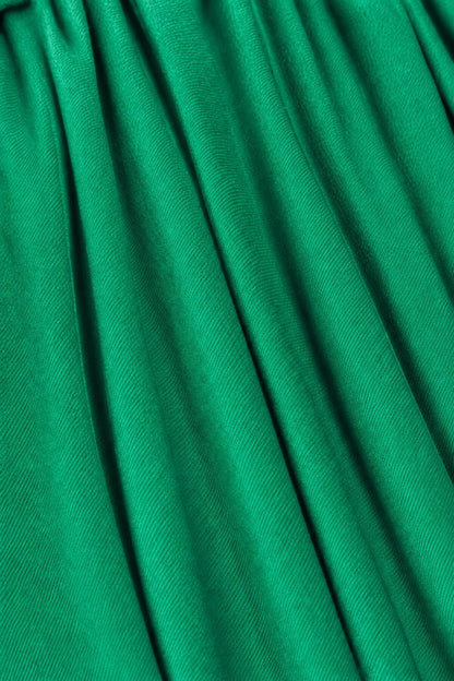 A close-up of bright green pleated fabric with soft vertical folds and a subtle sheen