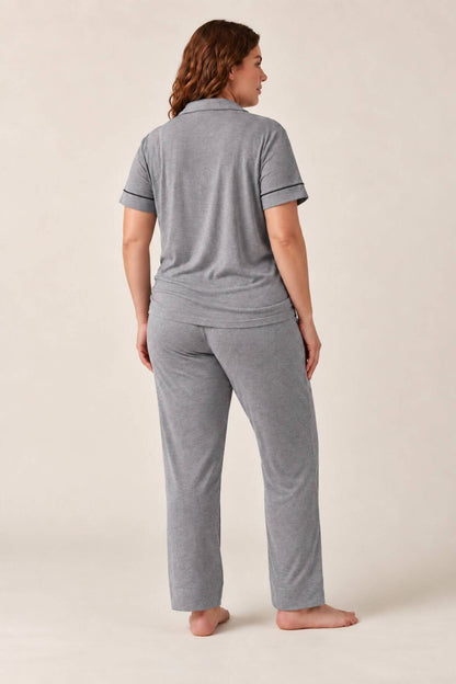 A woman wearing a heather gray short-sleeve polo shirt and matching heather gray lounge pants, shown from the back against a plain beige studio background.
