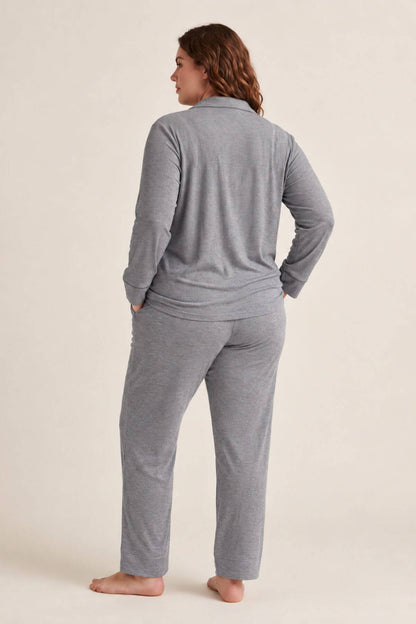 A woman wearing a heather gray long-sleeve top and matching pants, shown from the back against a plain light beige studio background.