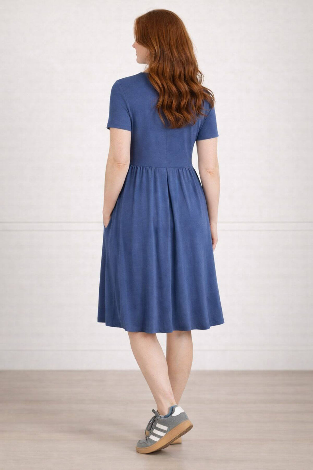 Woman wearing a dark blue nursing dress  for breastfeeding back view