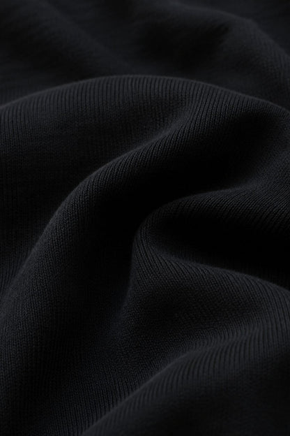 Close-up of dark ribbed fabric with soft folds and a smooth texture.