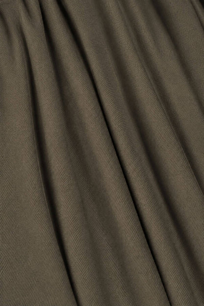 A close-up of draped fabric in a muted taupe-brown color, showing the texture and folds.