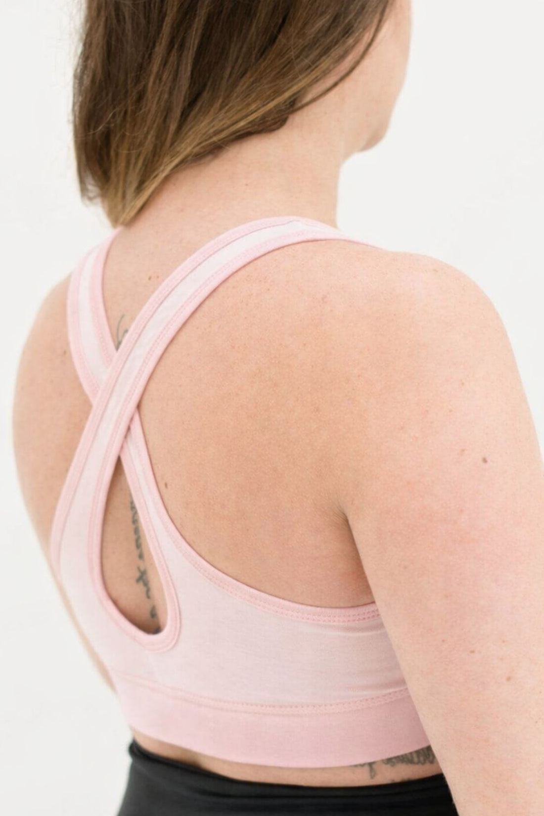 Woman wearing a light pink sleep nurisng bra back view