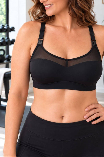 A woman wearing athe Stages sweetheart mesh racerback style nursing bra and black leggings in a bright gym setting.