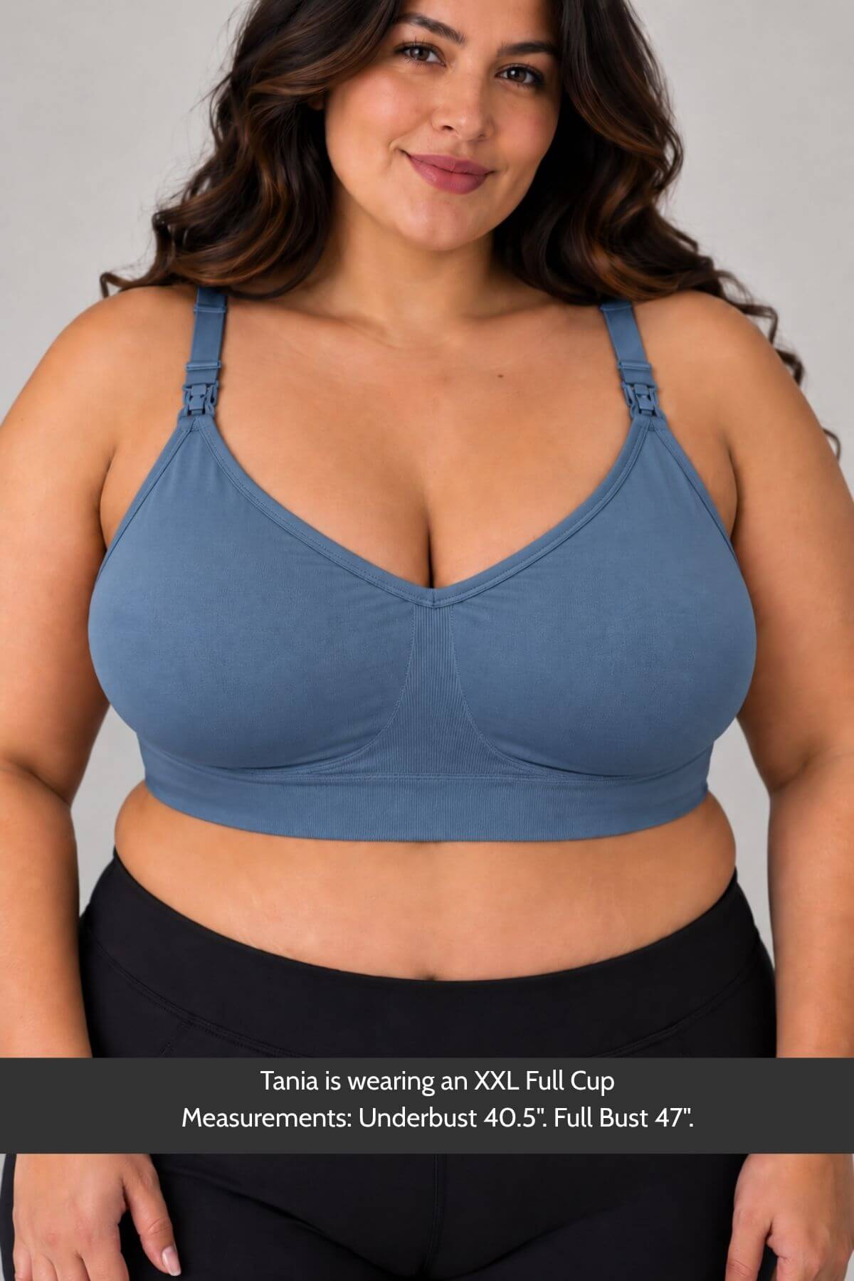 A plus-size woman wearing a simple wishes supermom silhouette nursing bra and hands free pumping bra in maine blue  and black leggings, shown against a light gray studio background with a text overlay at the bottom detailing cup measurements.