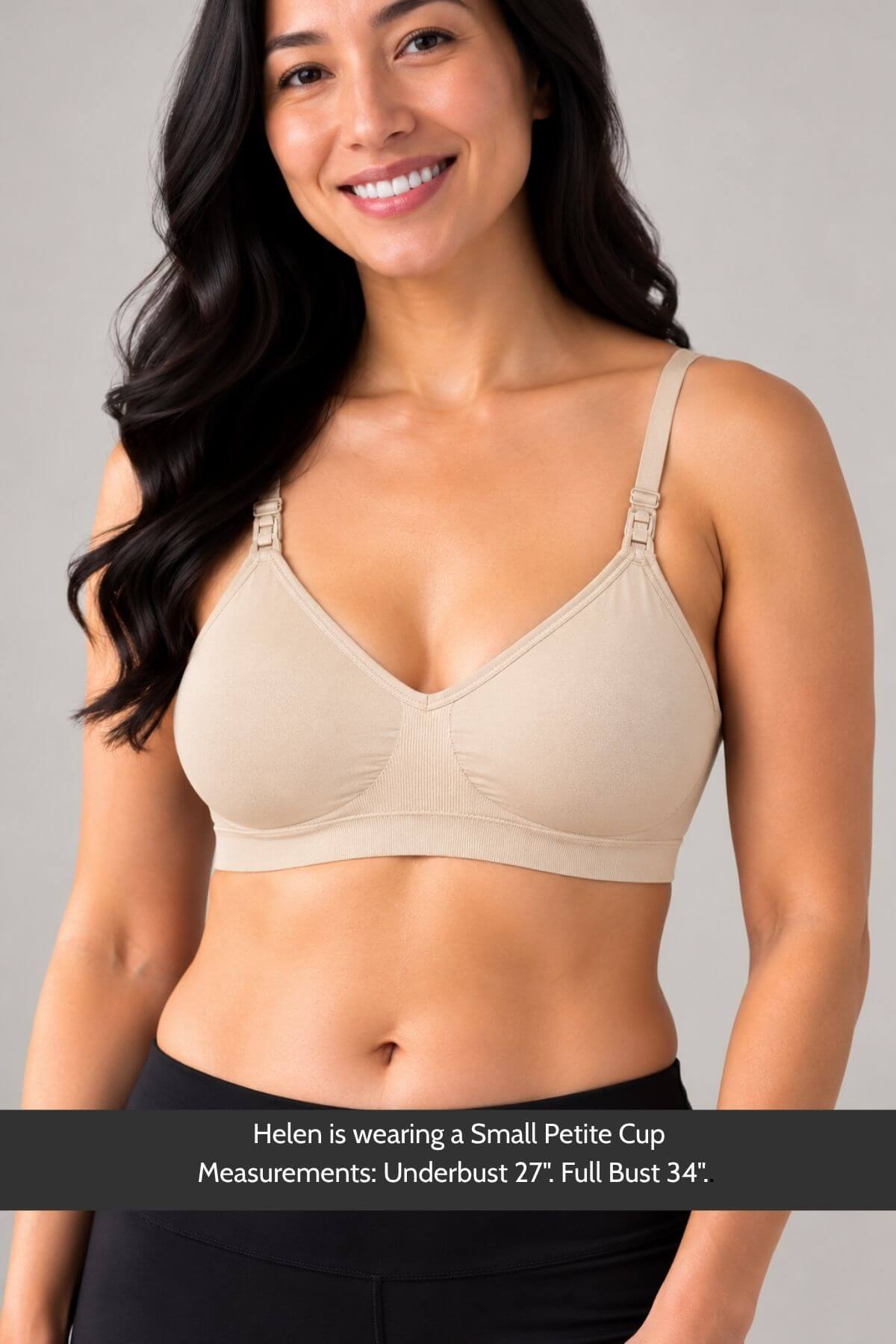 A smiling woman wearing the simple wishes supermom silhouette nursing and hands free pumping bra in beige with front adjustable shoulder straps, shown from the waist up against a light gray studio background. A text banner at the bottom reads: &