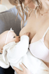 Stages Bra: A regular bra that converts to a nursing bra then back again to a regular bra. Ideal for your budget and earth friendly. In Ballet Slipper, this image shows the bra being worn with the nursing clasp bra straps attached and a lifestyle image of mom breastfeeding her baby.